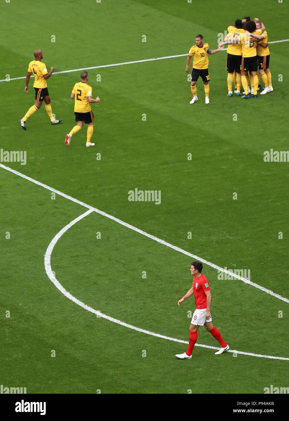 Inghilterra Harry Maguire (fondo) guarda come il Belgio celebrano il loro lato del primo obiettivo del gioco durante la Coppa del Mondo FIFA il terzo posto di play-off corrispondono a San Pietroburgo Stadium. Foto Stock