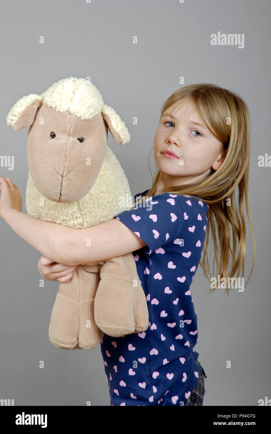 Emma mit ihrem kuscheligen Schaf. Foto Stock