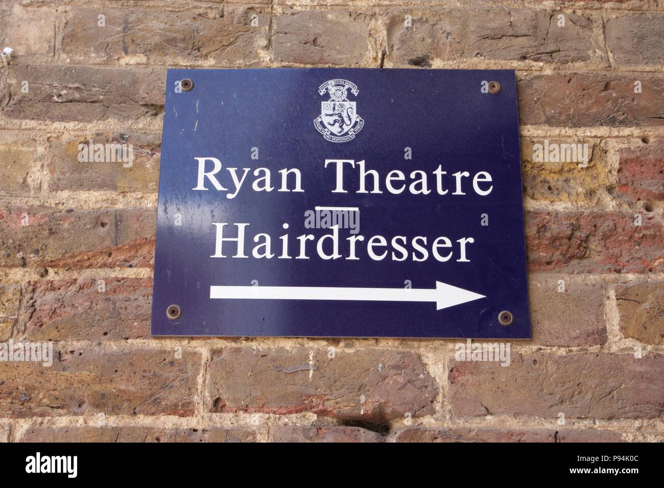 Un segno blu su un muro di mattoni per Ryan Teatro e parrucchiere a Harrow School, Harrow-On-The-Hill Foto Stock