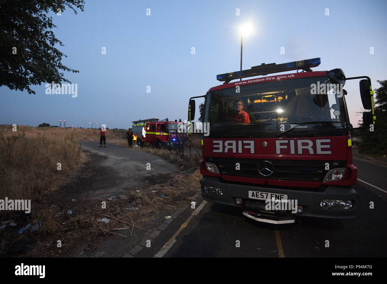 Il London Vigili del Fuoco combattendo un fuoco d'erba nei pressi dell'aeroporto di Heathrow la dimensione di quattro campi da calcio. Quindici motori Fire e 97 vigili del fuoco sono stati distribuiti per affrontare il blaze in Feltham, West London. Foto Stock
