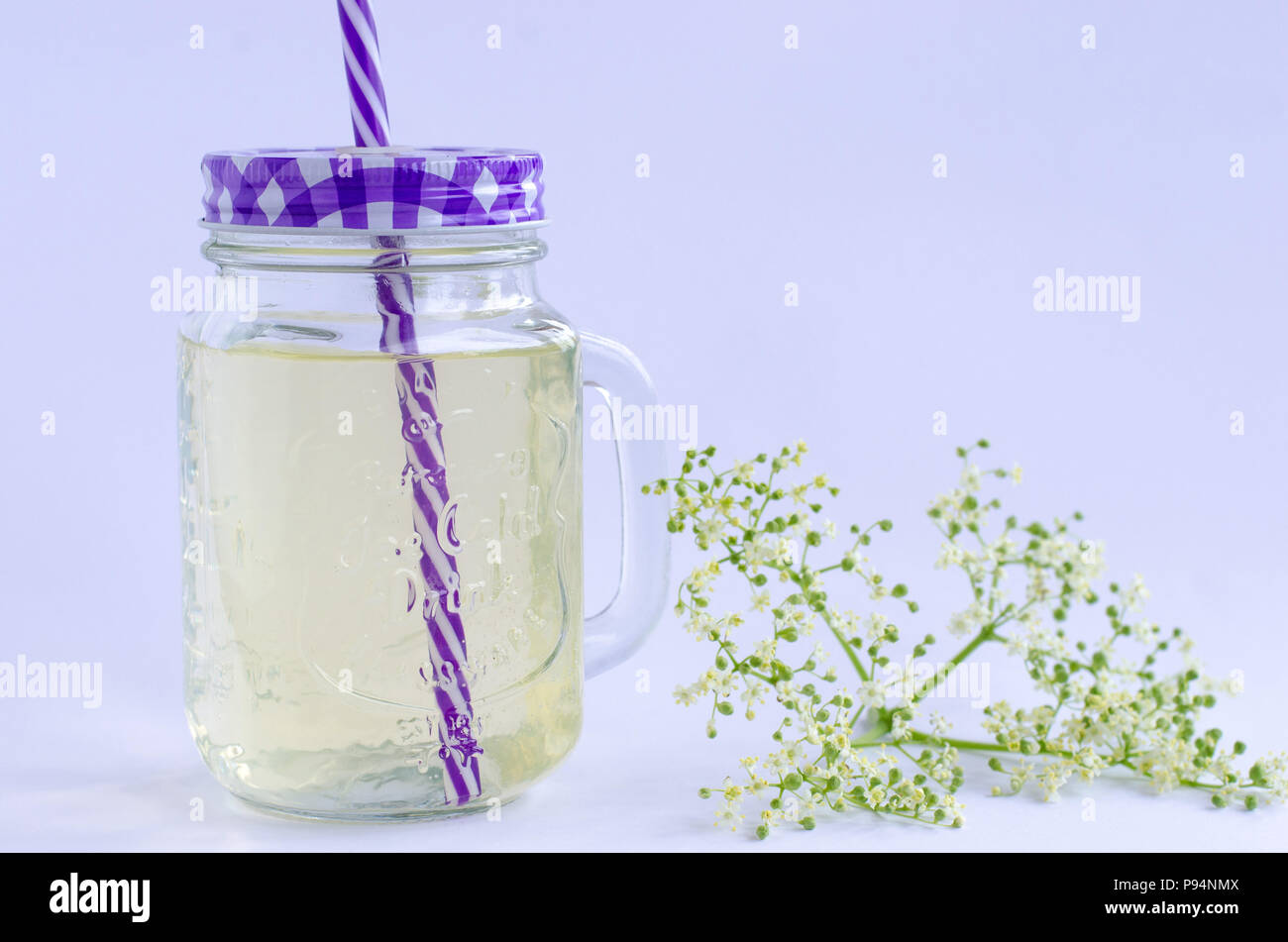 La realizzazione di lâ Elderflower limonata. Già pronta una bevanda di lâ Elderflower limonata con lâ Elderflower accanto ad esso con sfondo bianco. Foto Stock