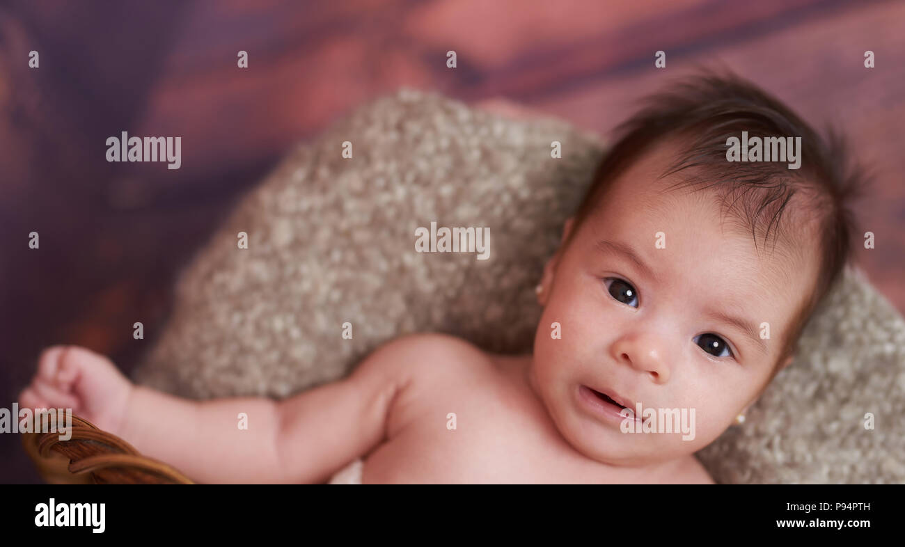 Ritratto di simpatici baby girl che stabilisce nel cestello superiore vista superiore Foto Stock