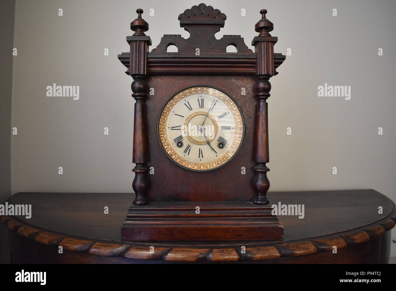 Il vecchio orologio in legno sul pezzo di mantello Foto Stock