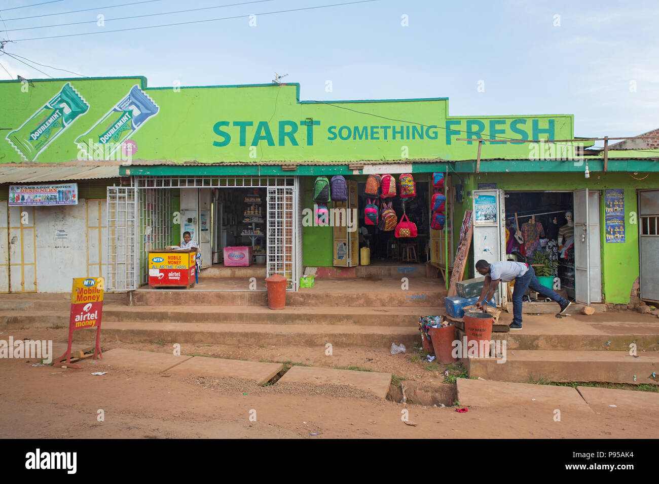 Wakiso Town, Uganda - Scene di strada. Store Negozi con il bubble gum reclaimer Foto Stock