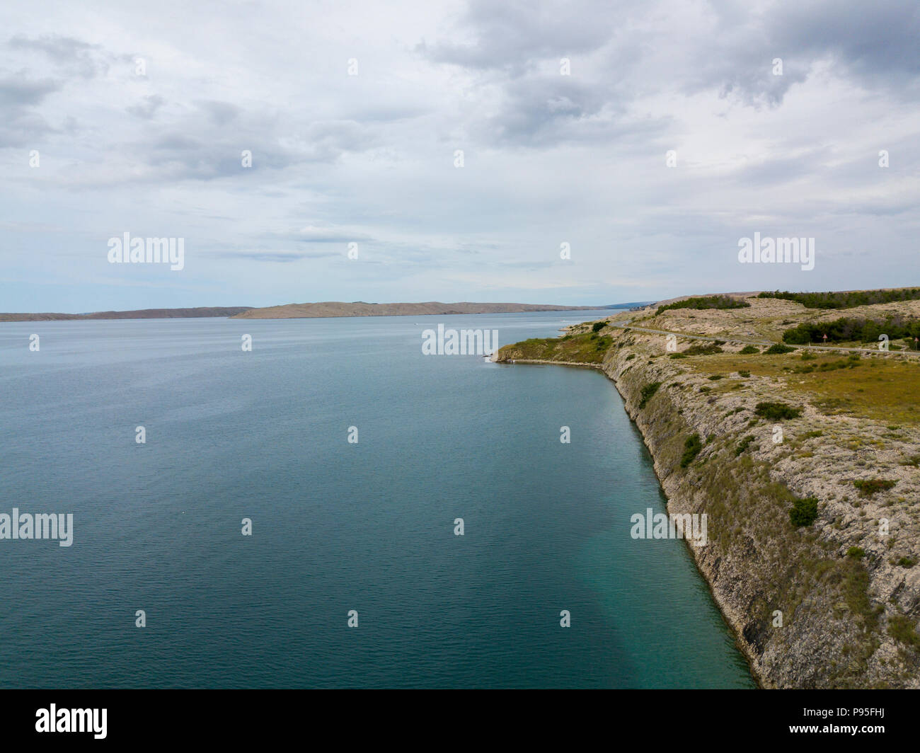 Vista aerea della costa della Croazia, strade tortuose e insenature con il mare limpido e cristallino. Costa dell'isola di Pag Foto Stock