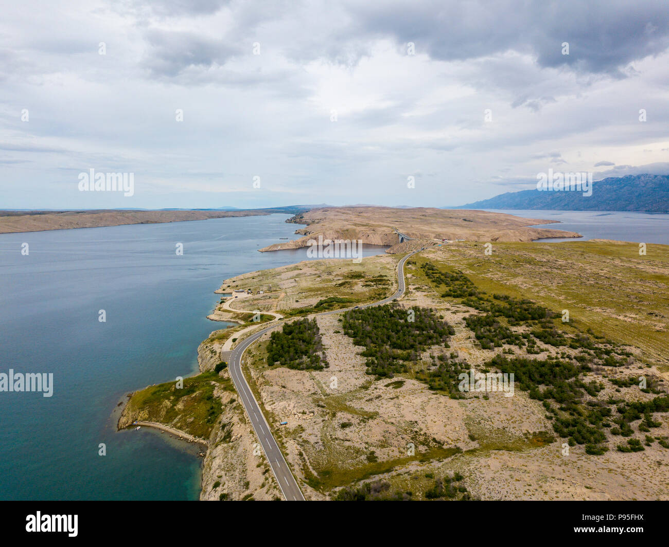 Vista aerea della costa della Croazia, strade tortuose e insenature con il mare limpido e cristallino. Costa dell'isola di Pag Foto Stock