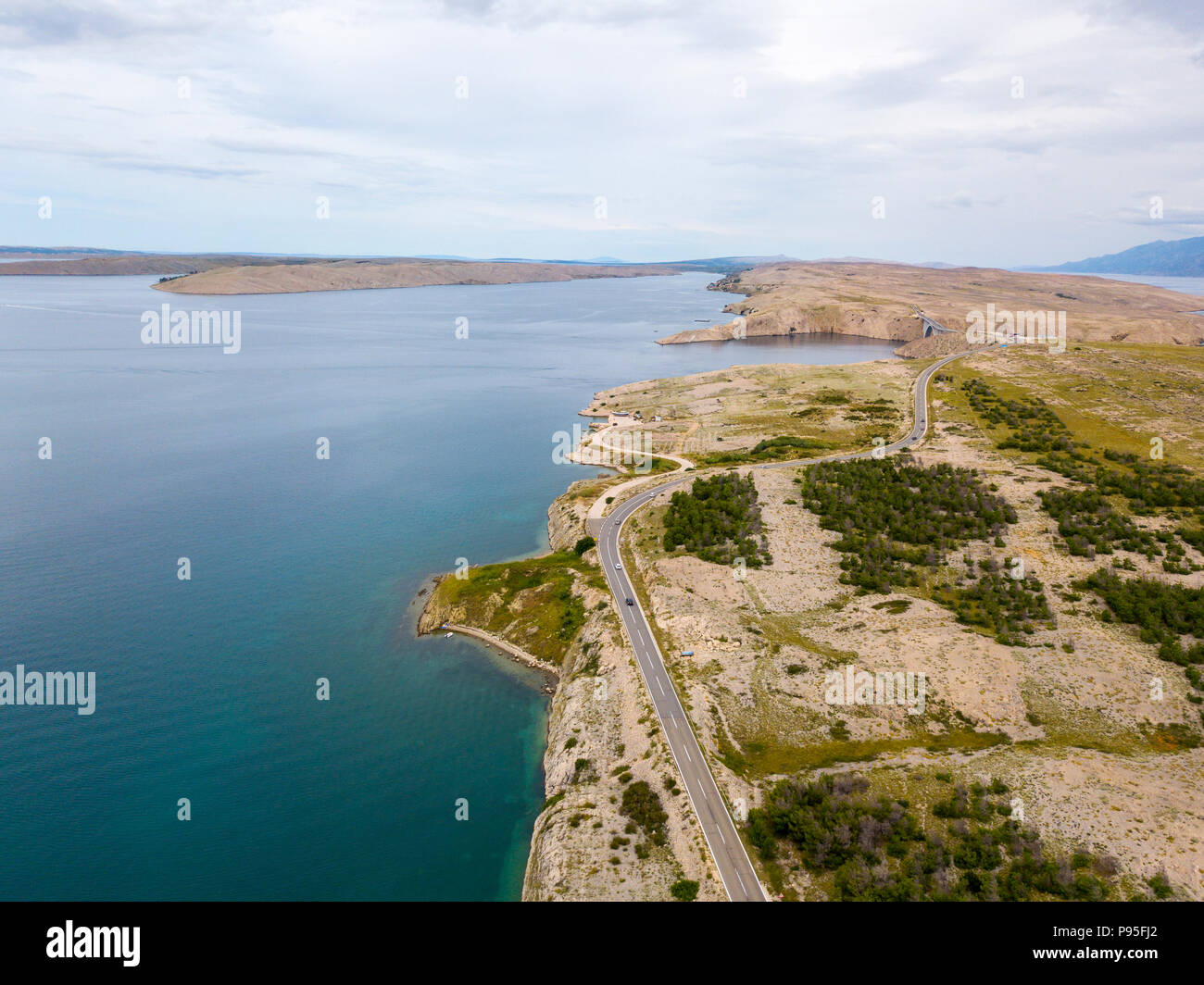 Vista aerea della costa della Croazia, strade tortuose e insenature con il mare limpido e cristallino. Costa dell'isola di Pag Foto Stock