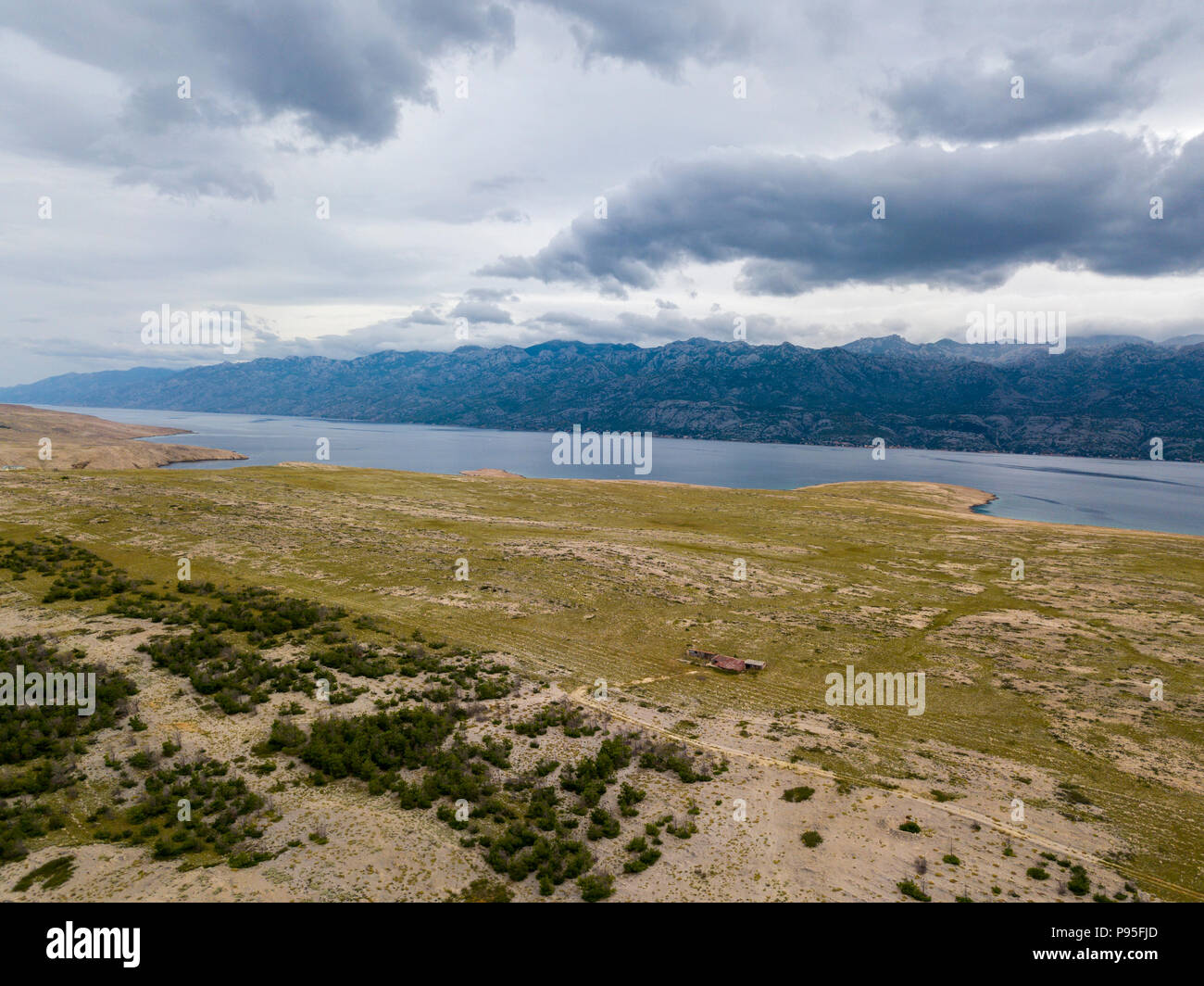 Vista aerea di una zona disabitata, natura selvaggia. Costa della Croazia. Isola di Pag e monti all'orizzonte Foto Stock