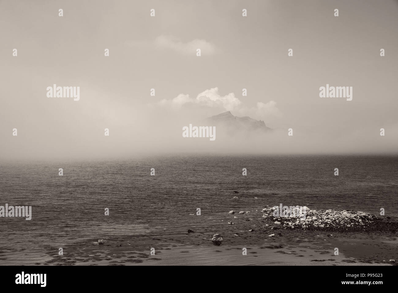 Cresta della collina che si rivelano dietro il cloud oltre il mare dall'Isola di Skye Foto Stock