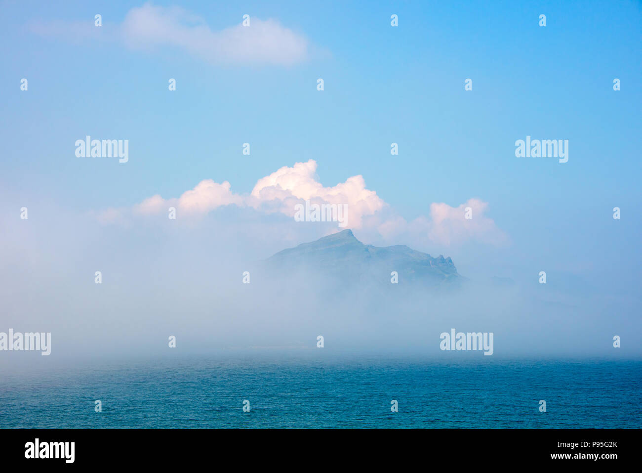 Cresta della collina che si rivelano dietro il cloud oltre il mare dall'Isola di Skye Foto Stock