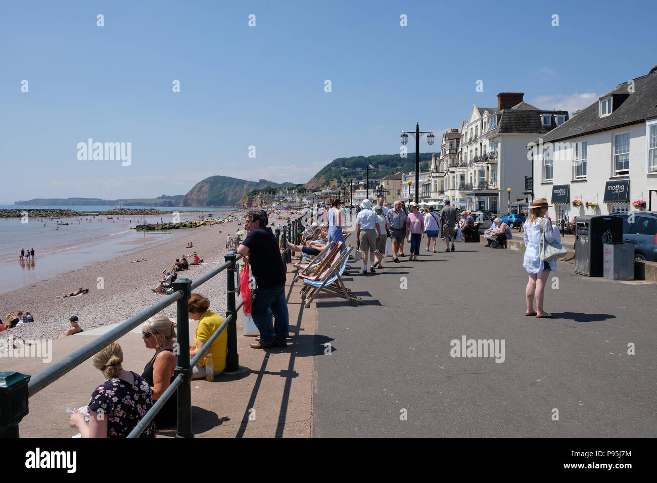 Vacanzieri godere di un caldo pomeriggio estivo all'Esplanade a Sidmouth, East Devon, Regno Unito Foto Stock