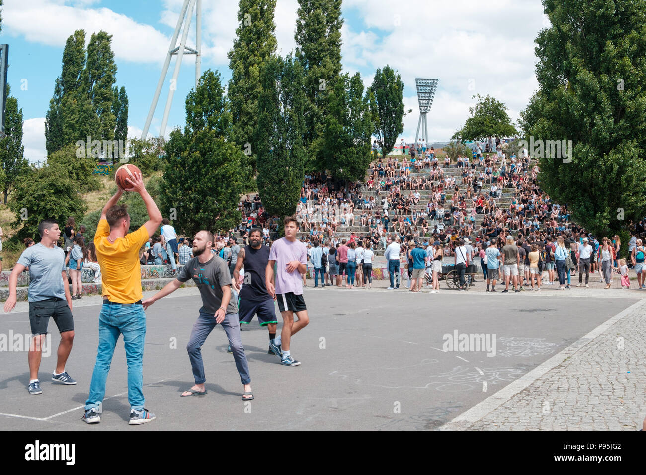 Berlino, Germania - Luglio 2018: i ragazzi e le ragazze a giocare a basket in park (Mauerpark) accanto alla folla di persone a anfiteatro guardando le prestazioni su un s Foto Stock