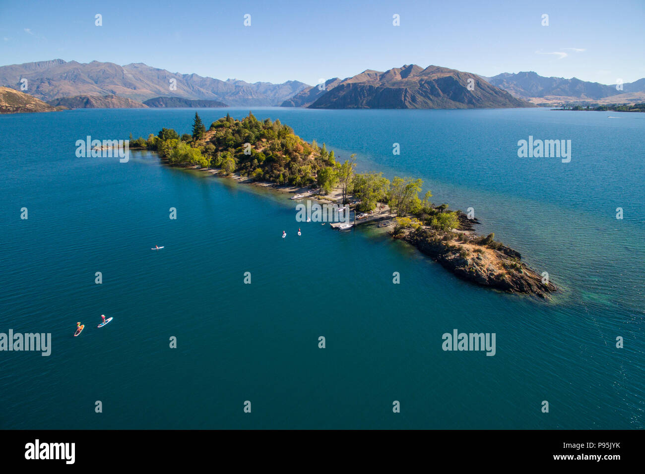 Antenna di stand up paddle boarders paddling a Ruby isola sul lago Wanaka, Nuova Zelanda Foto Stock