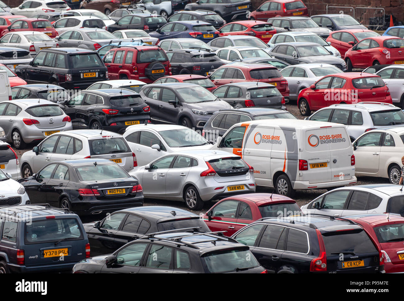 Vista in elevazione di veicoli (automobili e un furgone) parcheggiato in un parcheggio di Ardrossan Harbour, North Ayrshire, in Scozia, Regno Unito Foto Stock