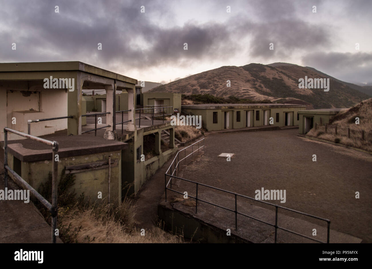 Le nuvole e il tramonto sopra le strutture abbandonate dell'ex base militare di batteria Spencer nella Marin Headlands al di fuori di San Francisco. Foto Stock