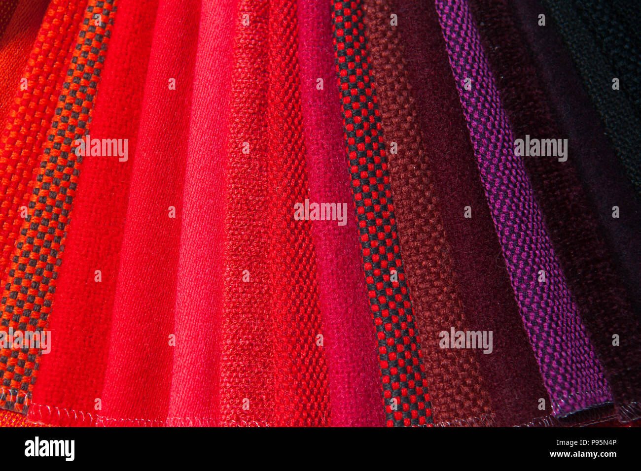 Tessuti rossi colorati in diversi stack di tonalità di colore nei livelli in esposizione. Foto Stock
