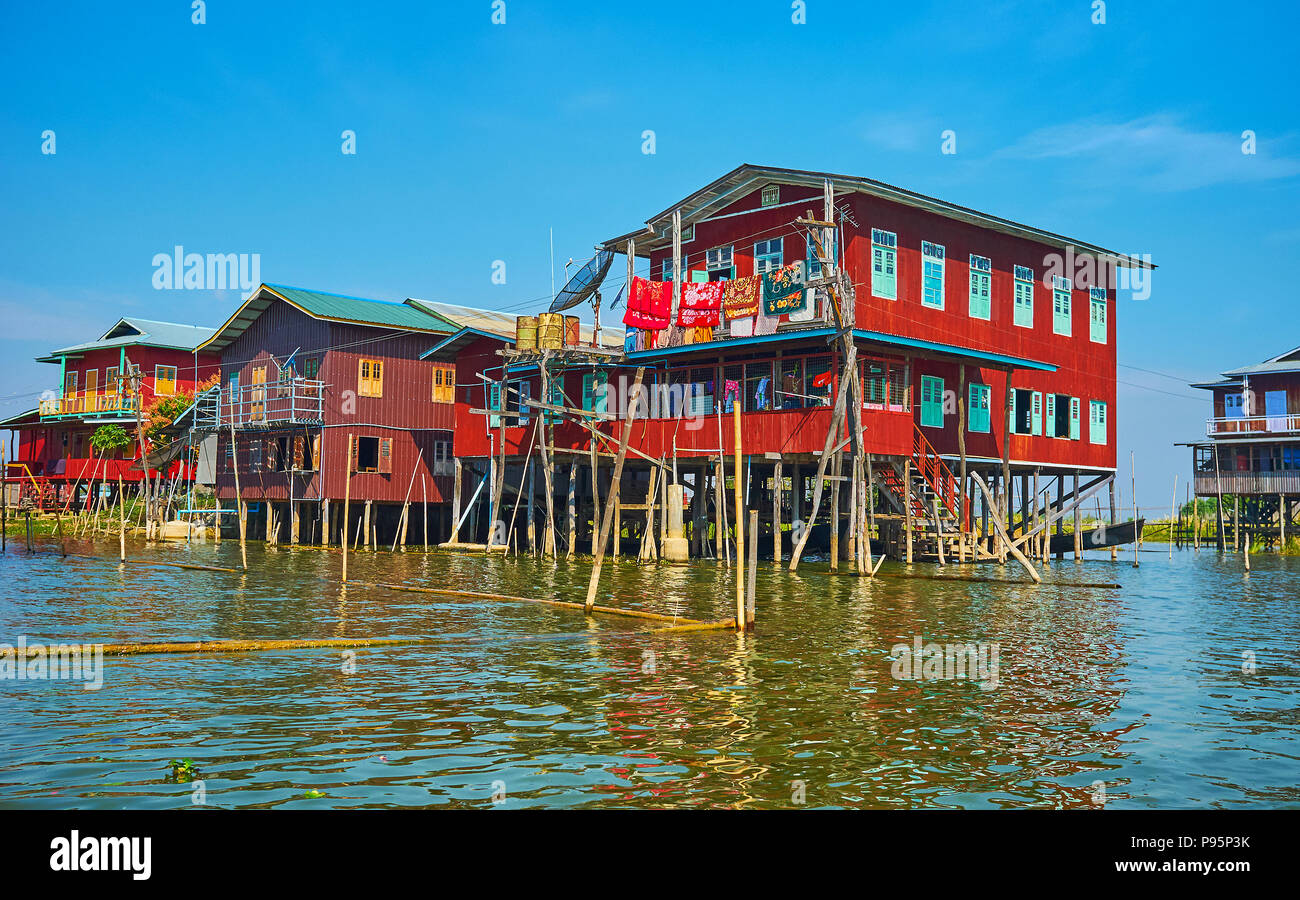 La fila di stilt case rosse di Inpawkhon villaggio sul Lago Inle, Myanmar. Foto Stock