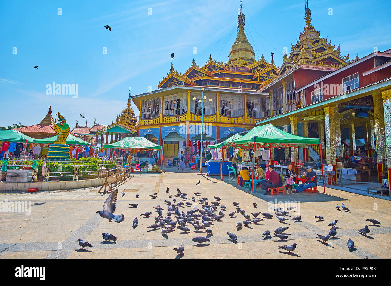 YWAMA, MYANMAR - 18 febbraio 2018: il gregge dei piccioni nel cortile di Hpaung Daw Pagoda U con il principale santuario, turistico si spegne e la fontana backgrou Foto Stock