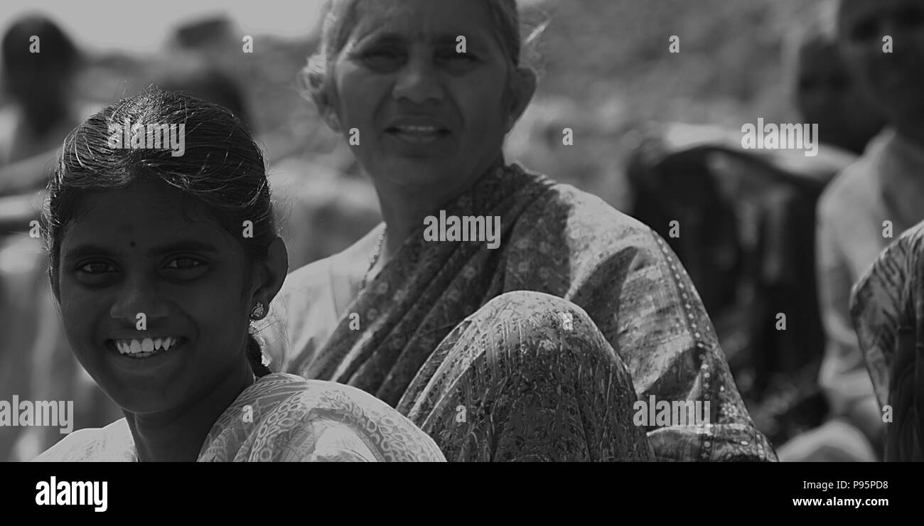 Sorridenti villaggio indiano le donne sedute a un campo di risone Foto Stock