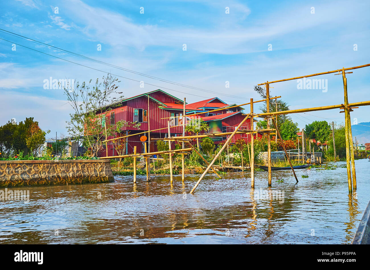 Il bambù traballante ponte sopra il canale nel villaggio di Ywama, situato sul Lago Inle, Myanmar. Foto Stock