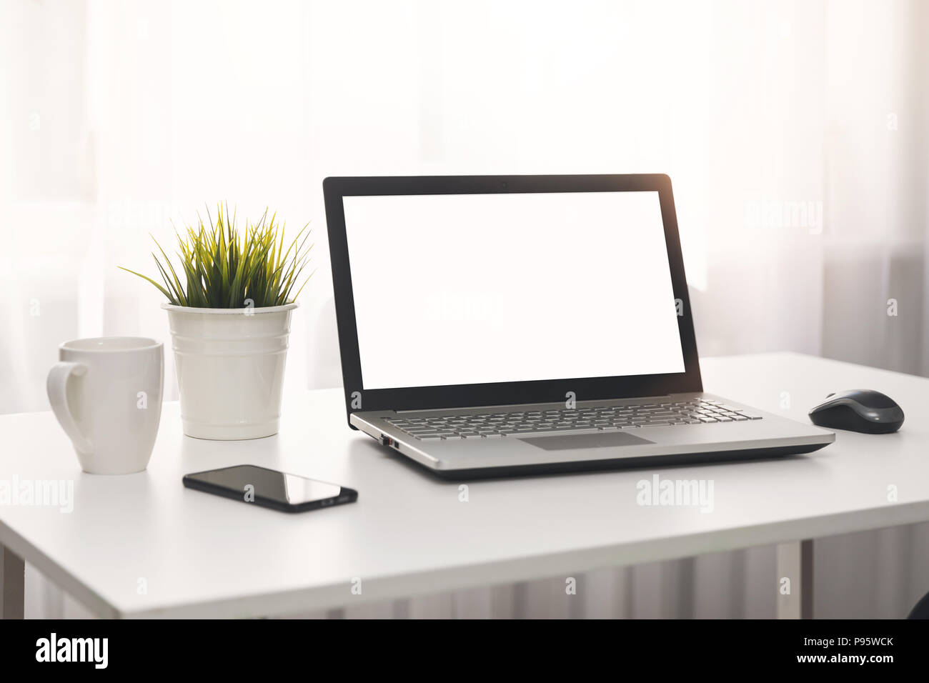 Bianco luminoso con il luogo di lavoro con computer portatile sul tavolo in camera Foto Stock