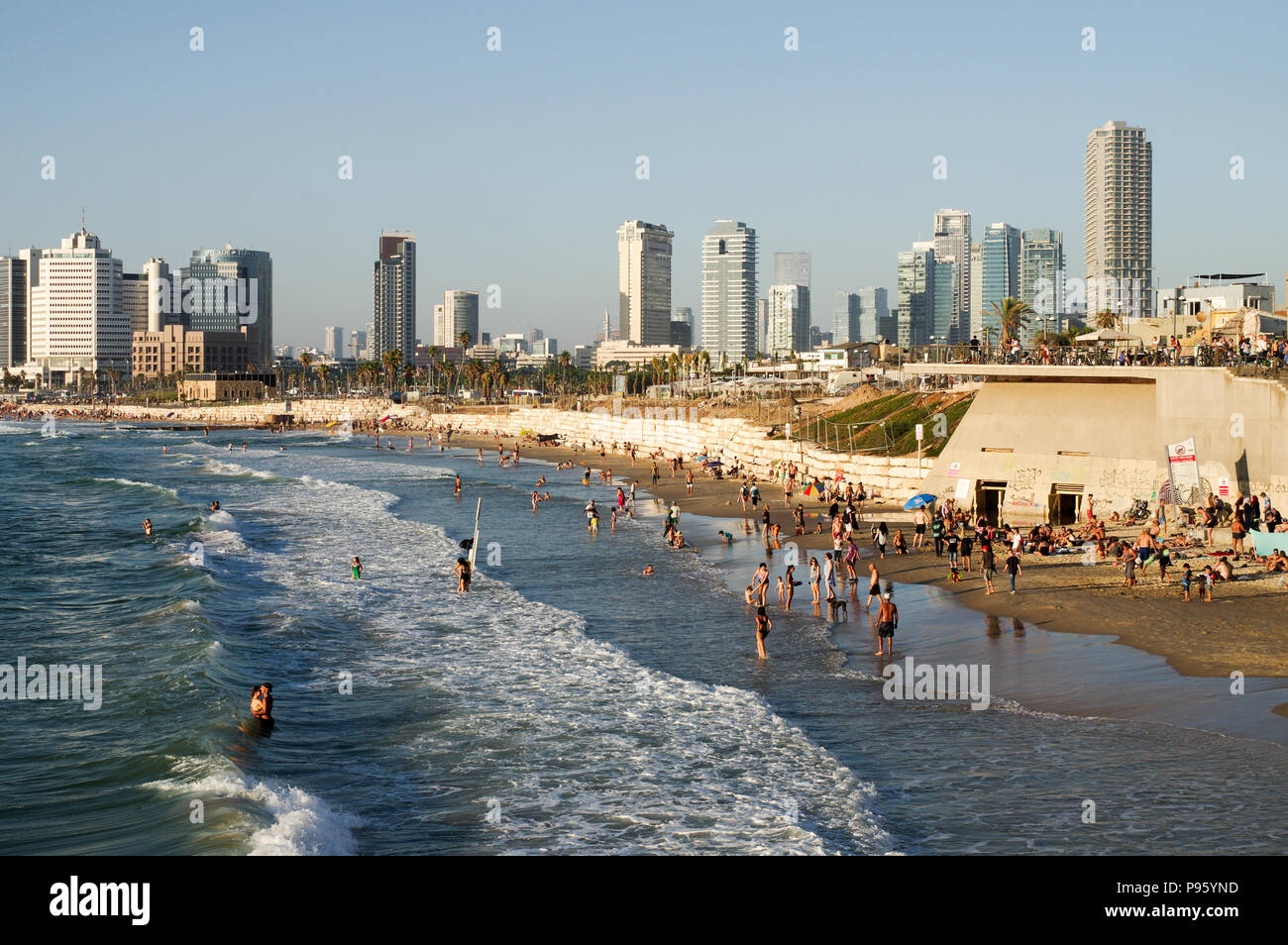 Bella Jaffa e Alma spiagge affollate di gente con Tel Aviv skyline in background Foto Stock