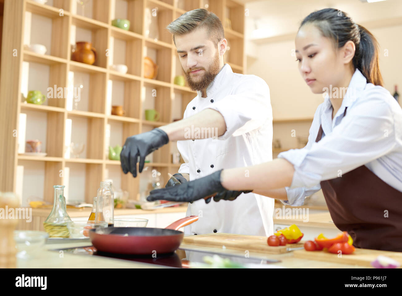 Due giovani chef operanti in cucina Foto Stock
