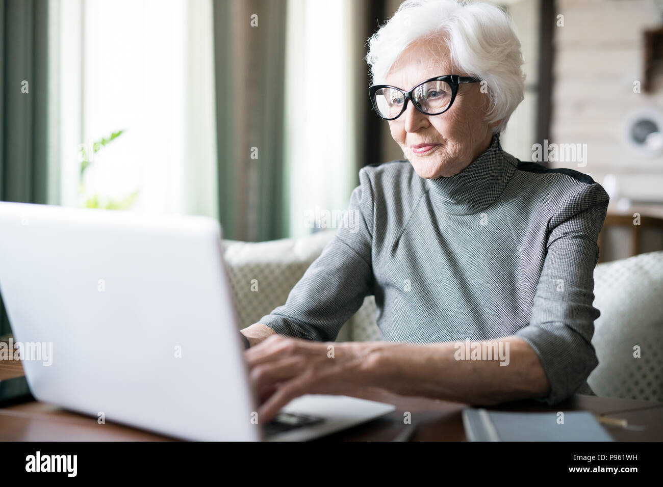 Senior donna digitando su laptop Foto Stock