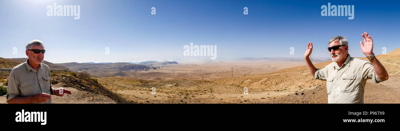Divertente fingere rapina nel panorama con il senior uomo in due pone affacciato sulla valle del deserto, Giordania, Medio Oriente Foto Stock