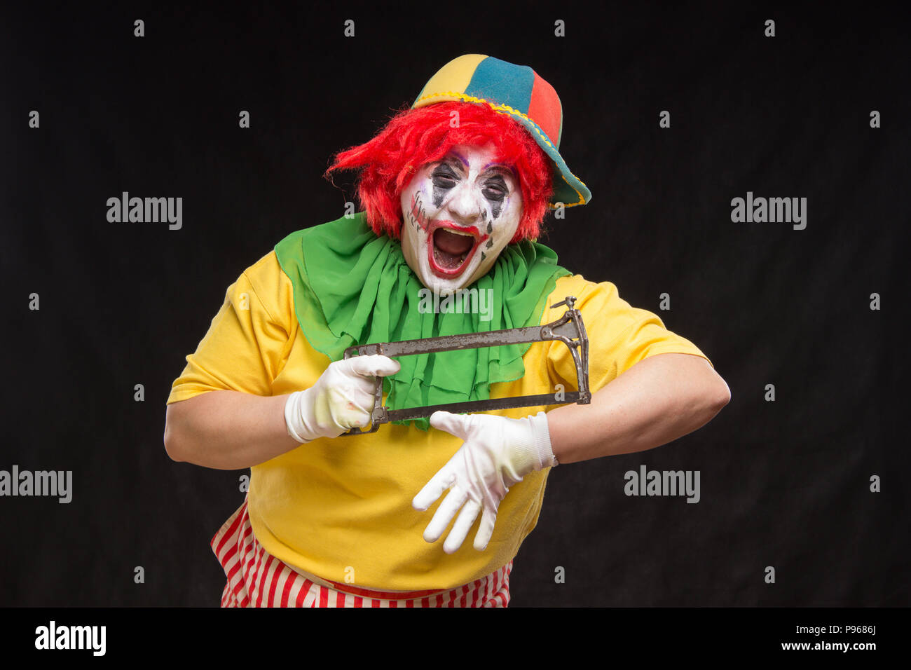 Scary evil clown con un brutto sorriso e visto su un nero backgroun Foto Stock