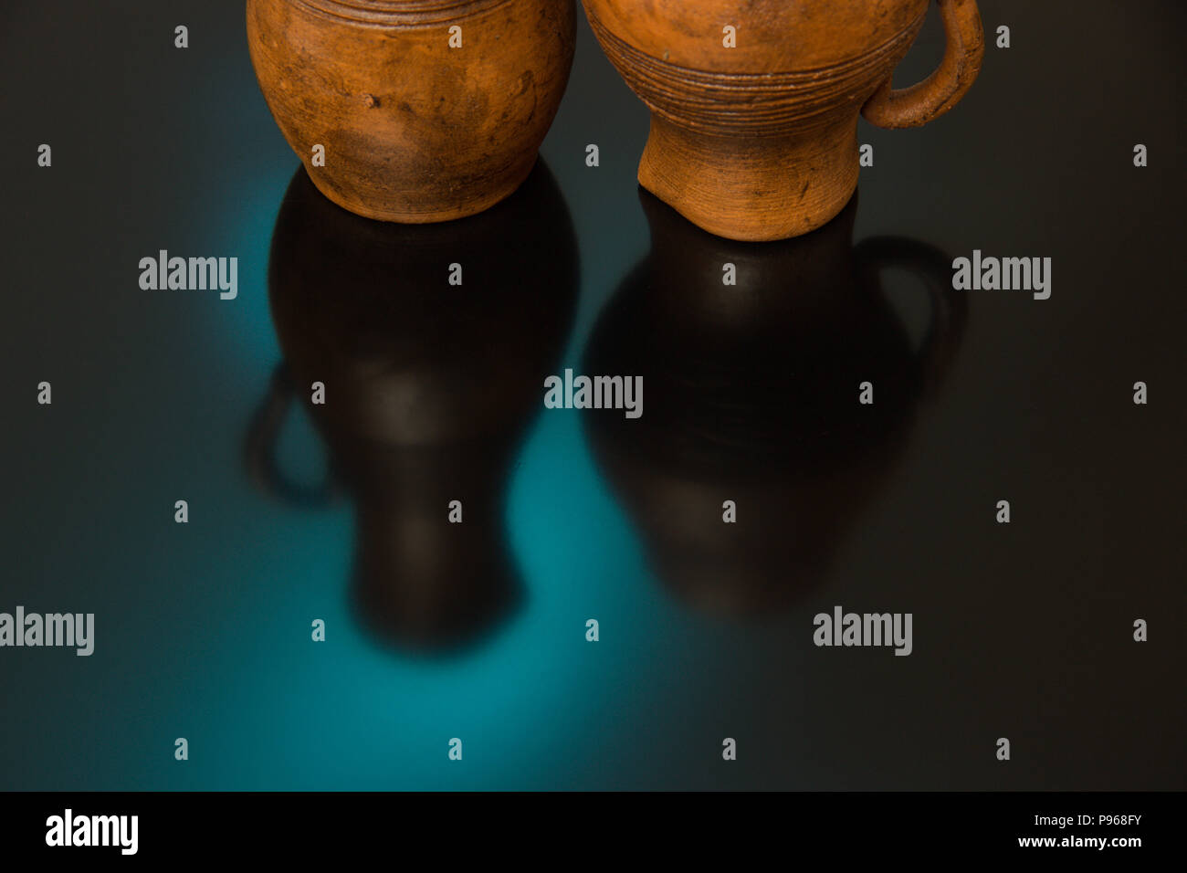 Vasi di ceramica con pattern scolpito su uno sfondo nero con il blu e il giallo luce Foto Stock