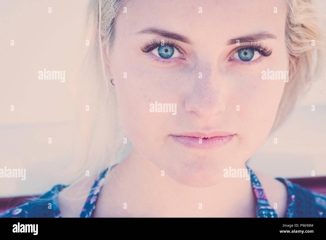 Ritratto sfocati con focus sull'occhio limpido di una bella russina caucasica ragazza giovane modello di sedersi e guardare a voi sulla fotocamera. piccolo sorriso relax Foto Stock