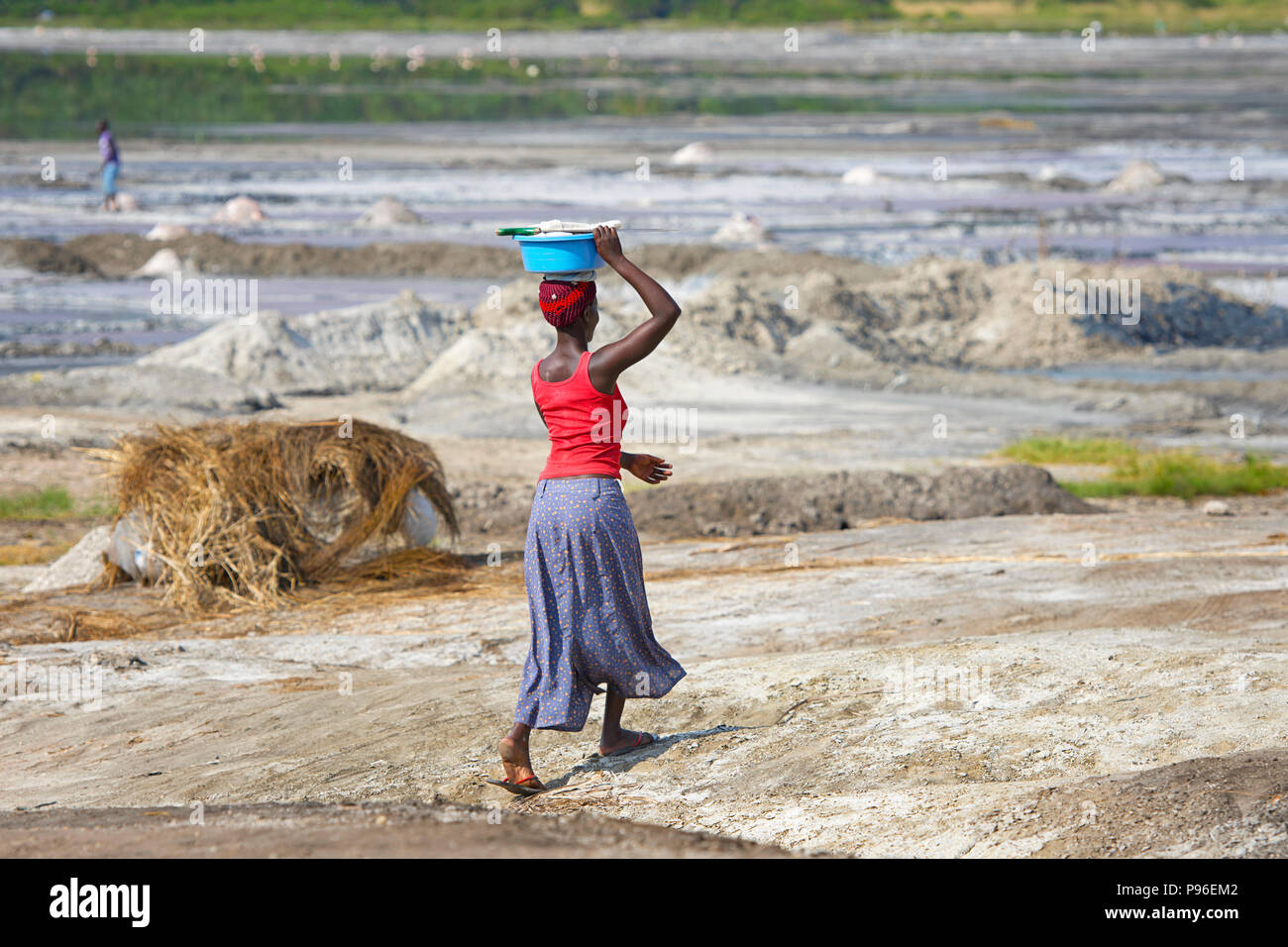 Donna africana a piedi bacino di trasporto sulla testa, Africa donna trasporta un carico al di sopra del suo capo, Uganda Foto Stock