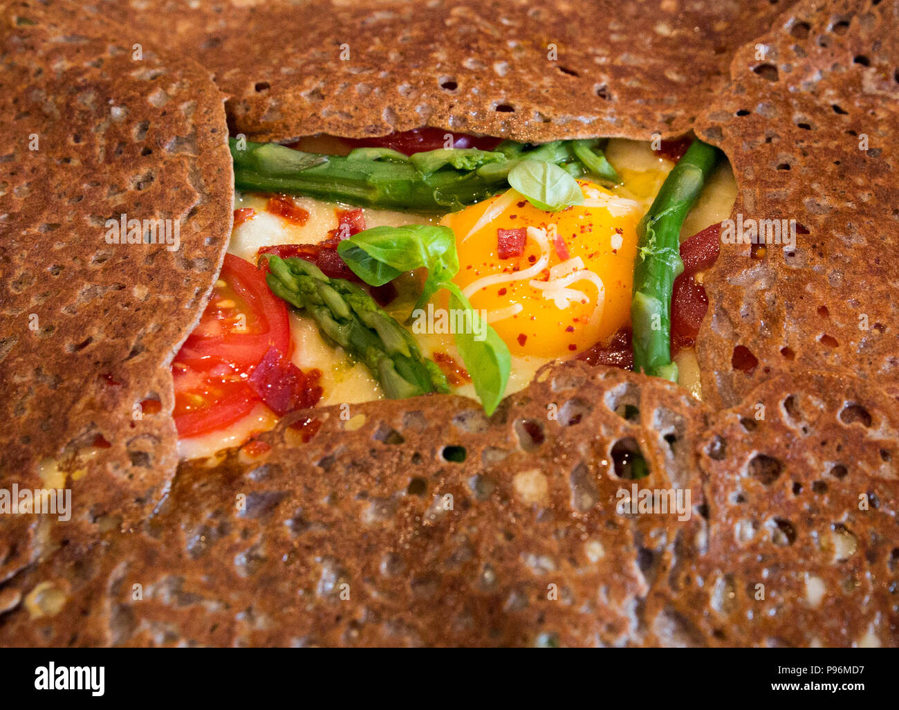 Close-up di un Breton grano saraceno galette riempito con verdure fresche e un uovo per pranzo a Parigi, Francia Foto Stock