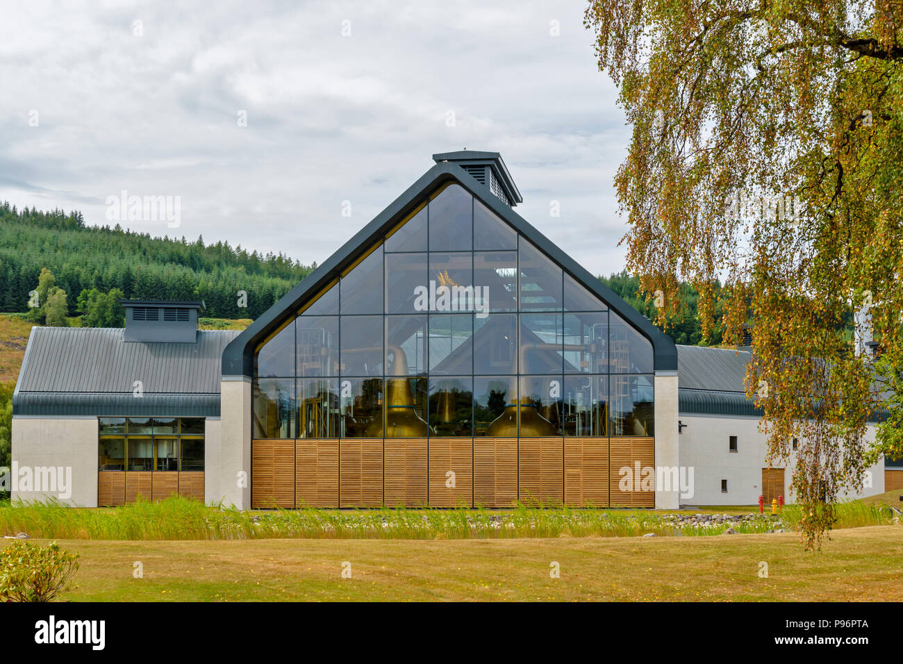 DALMUNACH distilleria di whisky CARRON MORAY SCOZIA FINE edificio contemporaneo a fianco del fiume Spey e SPEYSIDE strada o pista in estate Foto Stock