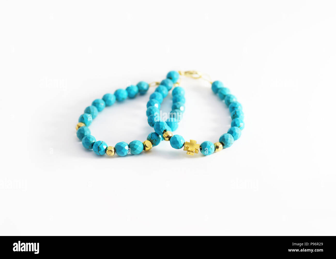 Still Life fotografia di gemma turchese bracciali con perline dorate e croce Foto Stock