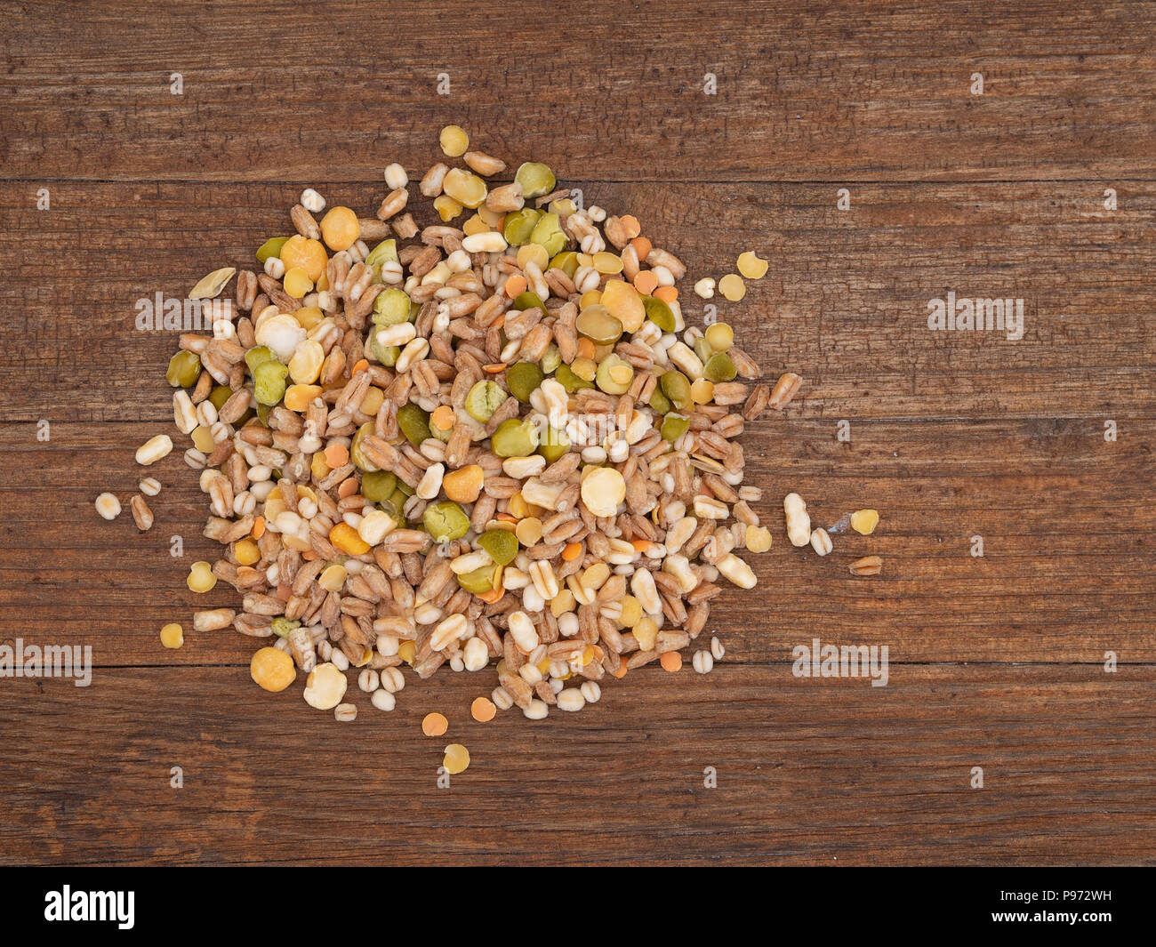Un assortimento di cereali e legumi mix su legno rustico scheda, vista aerea. Inverno include alimentari Piselli spezzati, rosso e giallo di lenticchie, farro, kamut, il farro. Foto Stock
