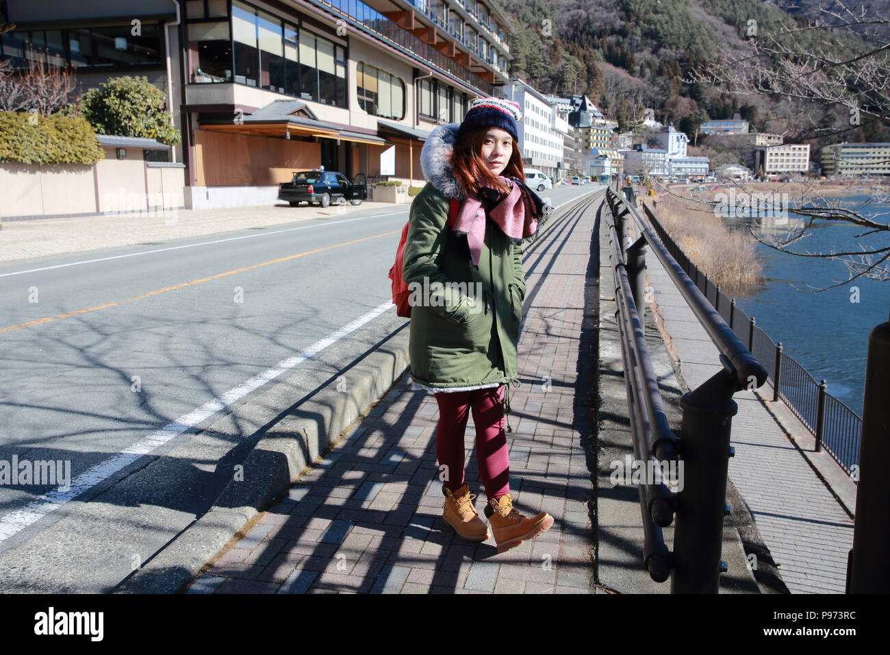 Donna attendere la fermata del bus in Giappone Foto Stock