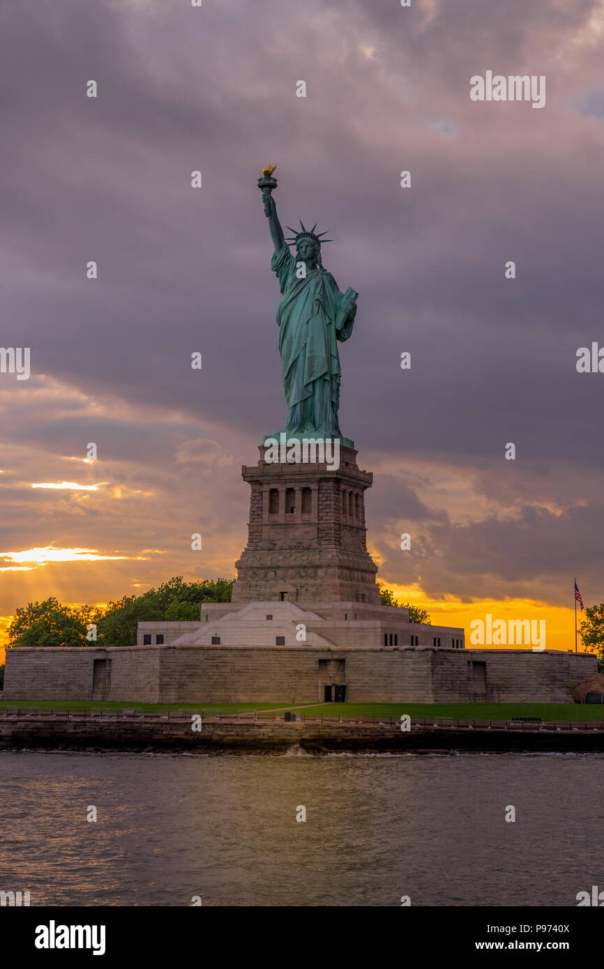 Vista al tramonto della statua della libertà nel porto di New York Foto Stock