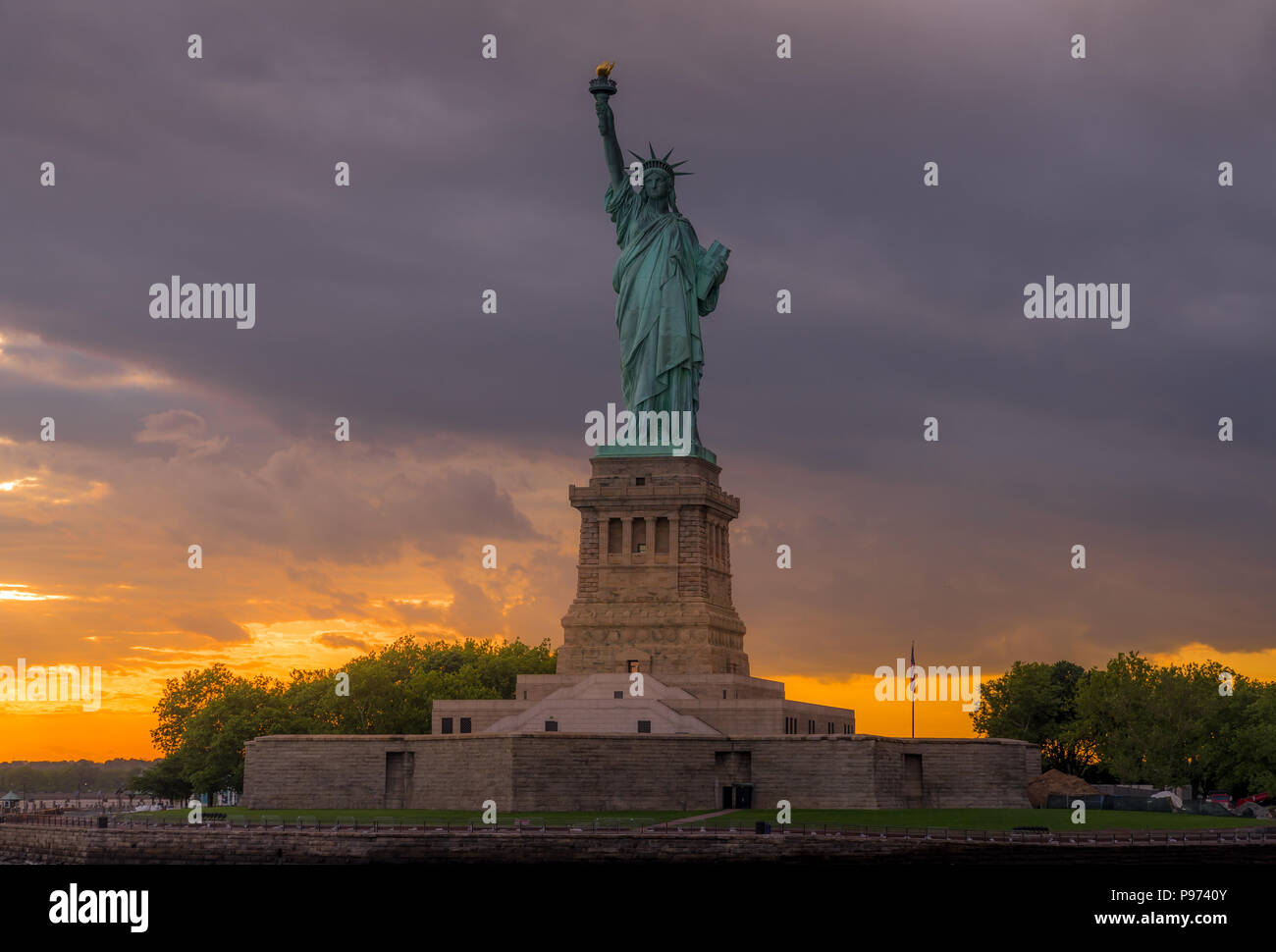 Vista al tramonto della statua della libertà nel porto di New York Foto Stock