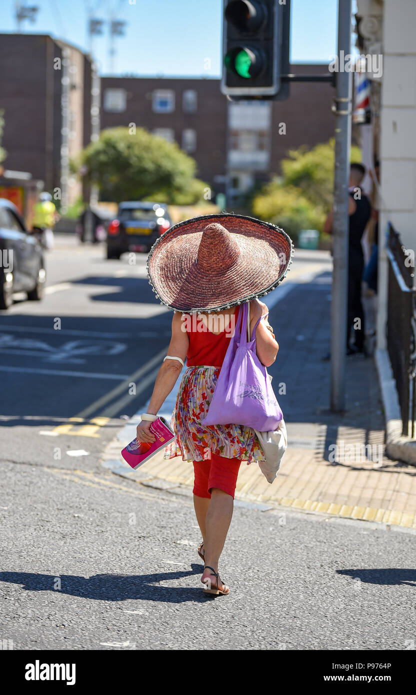 Brighton Regno Unito 15 luglio 2018 - questa donna indossa un enorme cappello a rimanere in ombra in Brighton come le temperature si elevano in basso la 30s in alcune parti del Sud Est della Gran Bretagna oggi Credito: Simon Dack/Alamy Live News Foto Stock