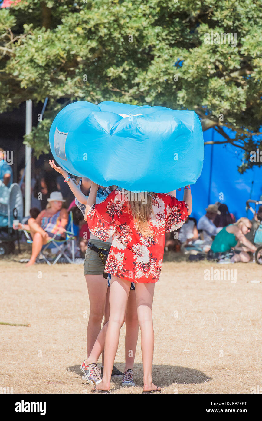 Suffolk, Regno Unito. Il 15 luglio 2018.Suffolk, Regno Unito. Il 15 luglio 2018.Suffolk, Regno Unito. Il 15 luglio 2018. È così caldo oggi che tutti gli alberi di ombra può fornire è utilizzato e vi è una vasta gamma di copricapi per quelli al sole - Il 2018 Latitude Festival, Henham Park. Suffolk 15 luglio 2018 Credit: Guy Bell/Alamy Live News Credito: Guy Bell/Alamy Live News Credito: Guy Bell/Alamy Live News Foto Stock