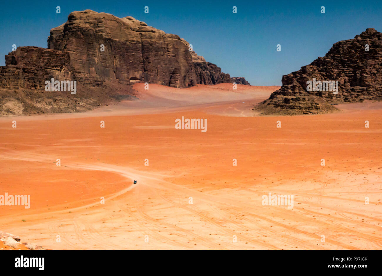 Veicolo 4x4 e tracce in vaste distese desolate, Wadi Rum vallata desertica con montagne, Giordania, Medio Oriente Foto Stock
