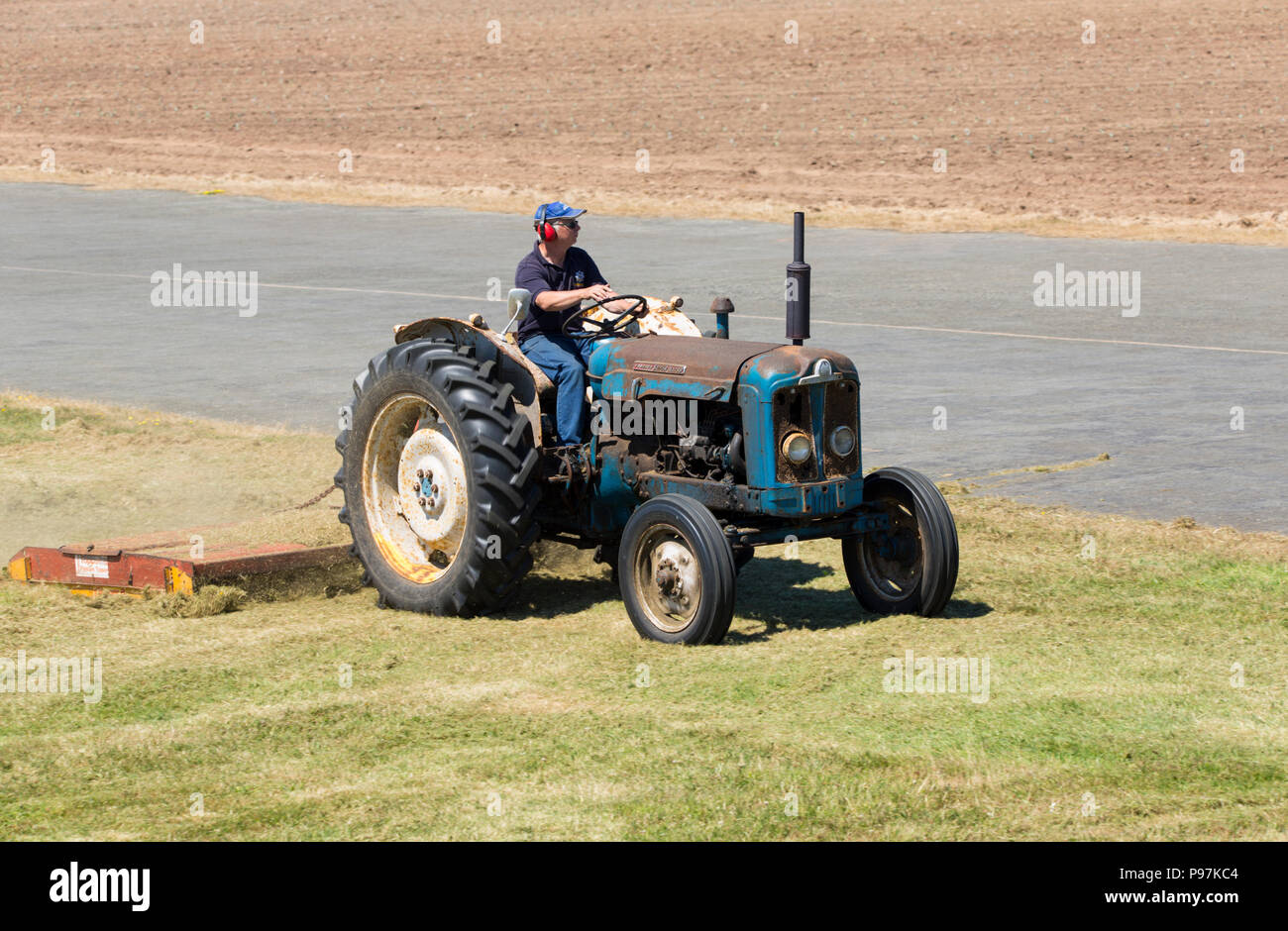 Vecchio Fordson Super Major il taglio di erba a Perranporth airfield Foto Stock
