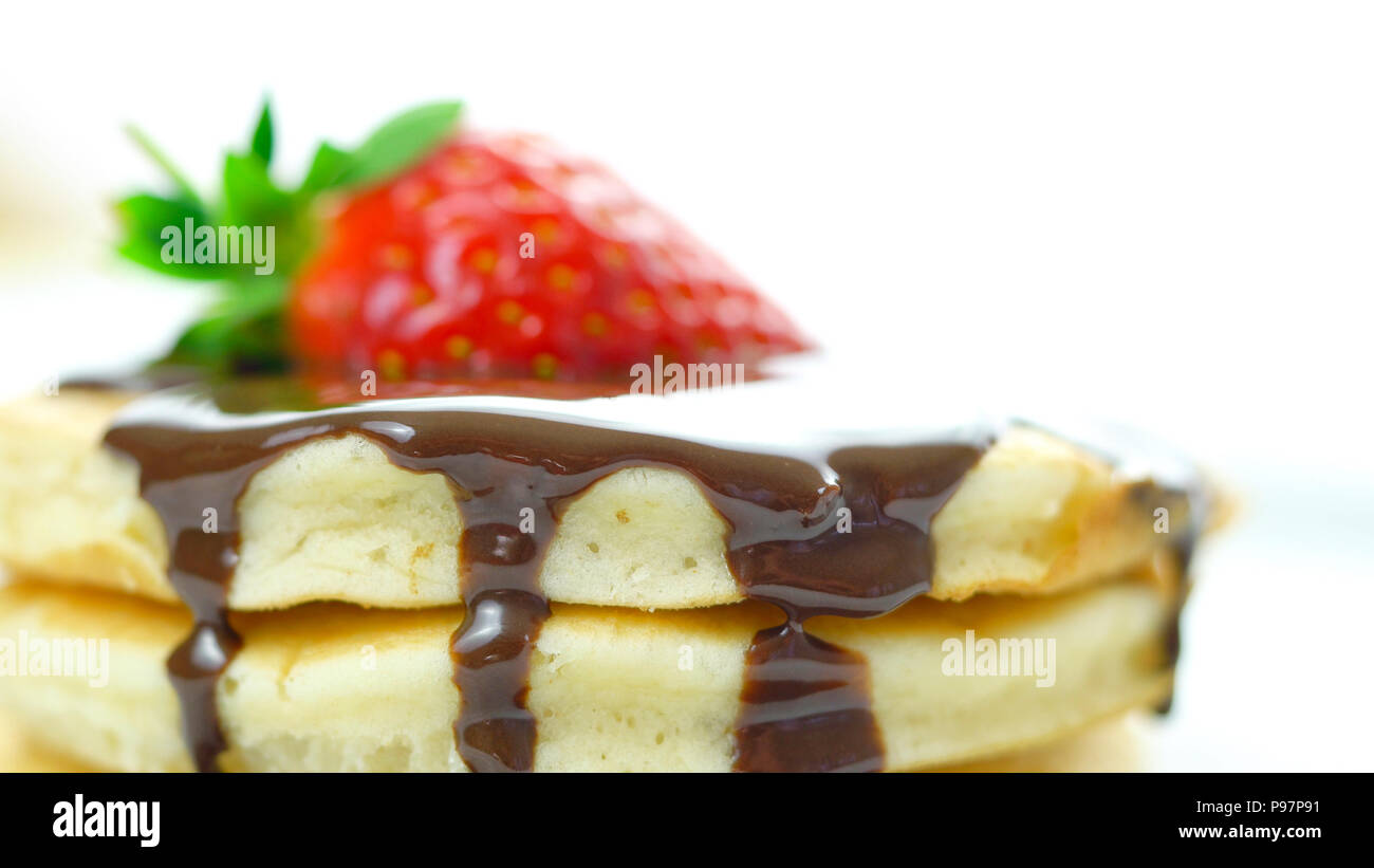 Pila di pancake con fragole e spruzzata con salsa di cioccolato, macro closeup. Foto Stock