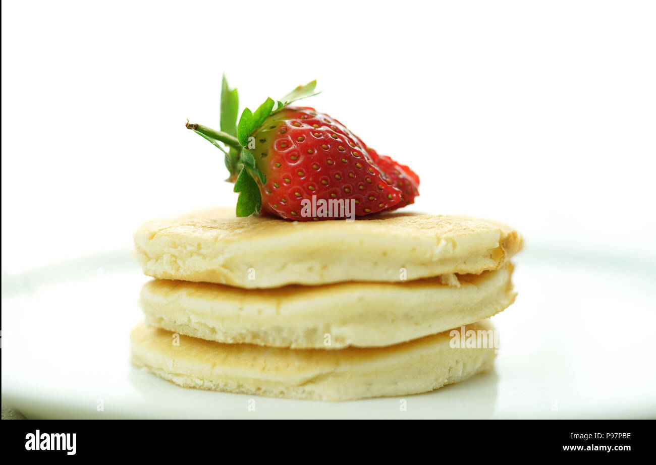 Pila di pancake con fragole in cima, macro closeup. Foto Stock