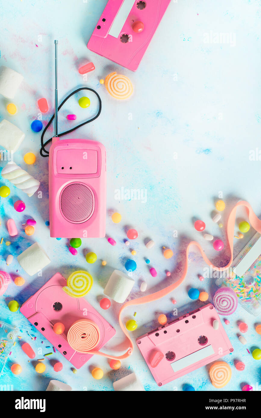 Candy cassette in una piacevole musica concetto. Caramelle, spruzza e marmellate di frutta su uno sfondo luminoso con copia spazio. Color pastello laici piatta Foto Stock
