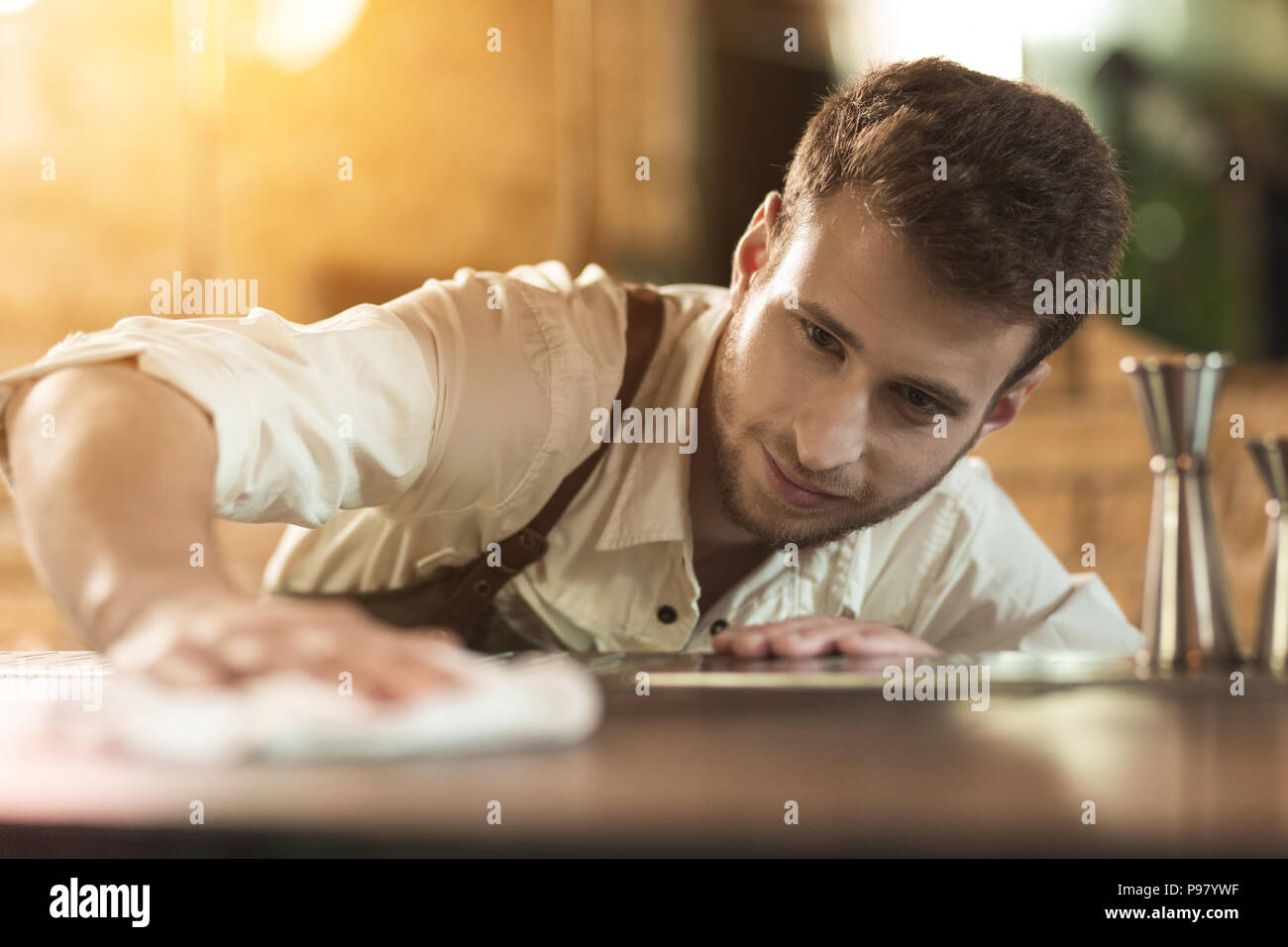 Affascinante giovane barista pulizia bancone bar Foto Stock