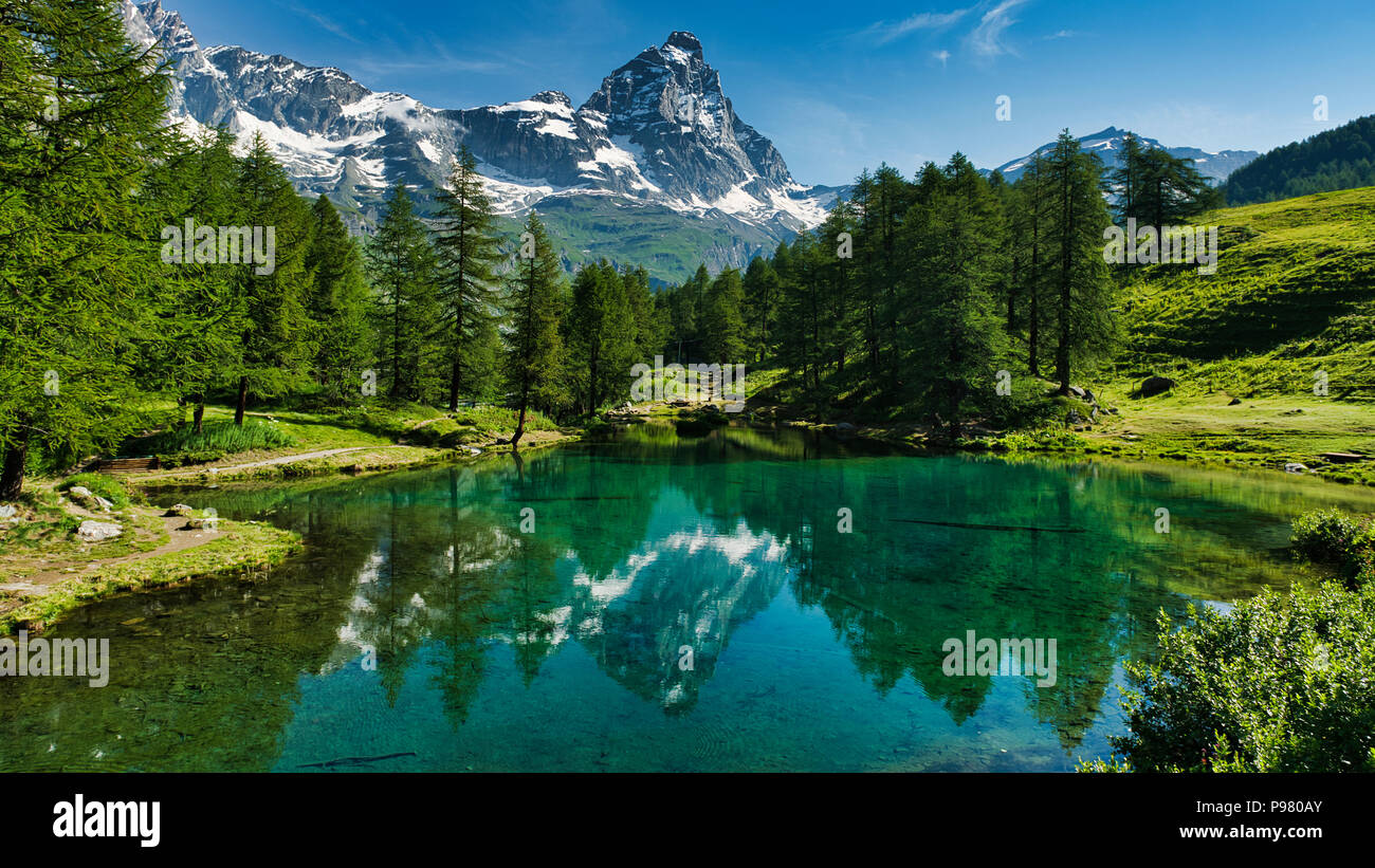 Il lago blu e il Monte Cervino in un pittoresco paesaggio estivo soleggiato con le luci visto da Breuil-Cervinia, Valle d'Aosta - Italia Foto Stock