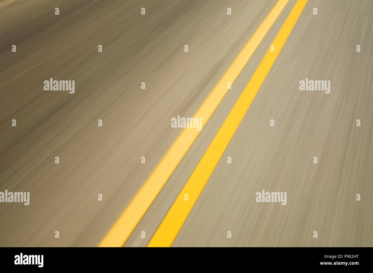 Il movimento sfocati doppio giallo linee su strada Foto Stock